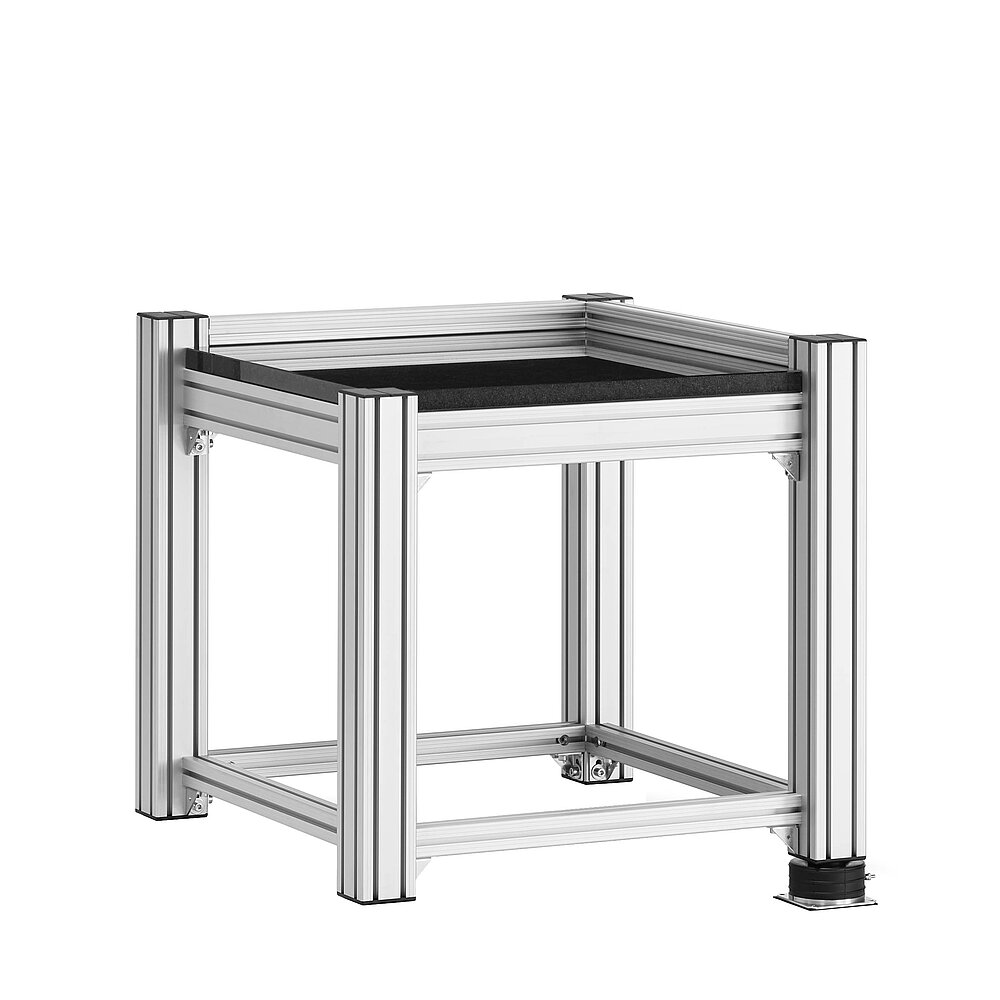a square, cube-shaped metrology table made of aluminium profiles, with thick black granite table top, mounted on one black air-cushion vibro-mount FLN, isolated on white background