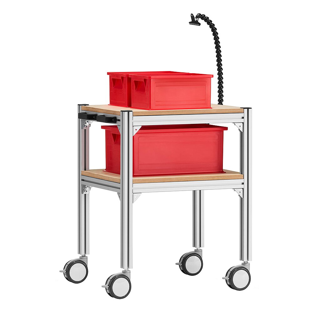 a small trolley made of aluminium profiles, with two storeys, wooden inlay shelvings, black pushbar handle made of plastics, four large, fastenable & turnable wheels, three red EURO stackable boxes and gooseneck-clip document holder, isolated on white background