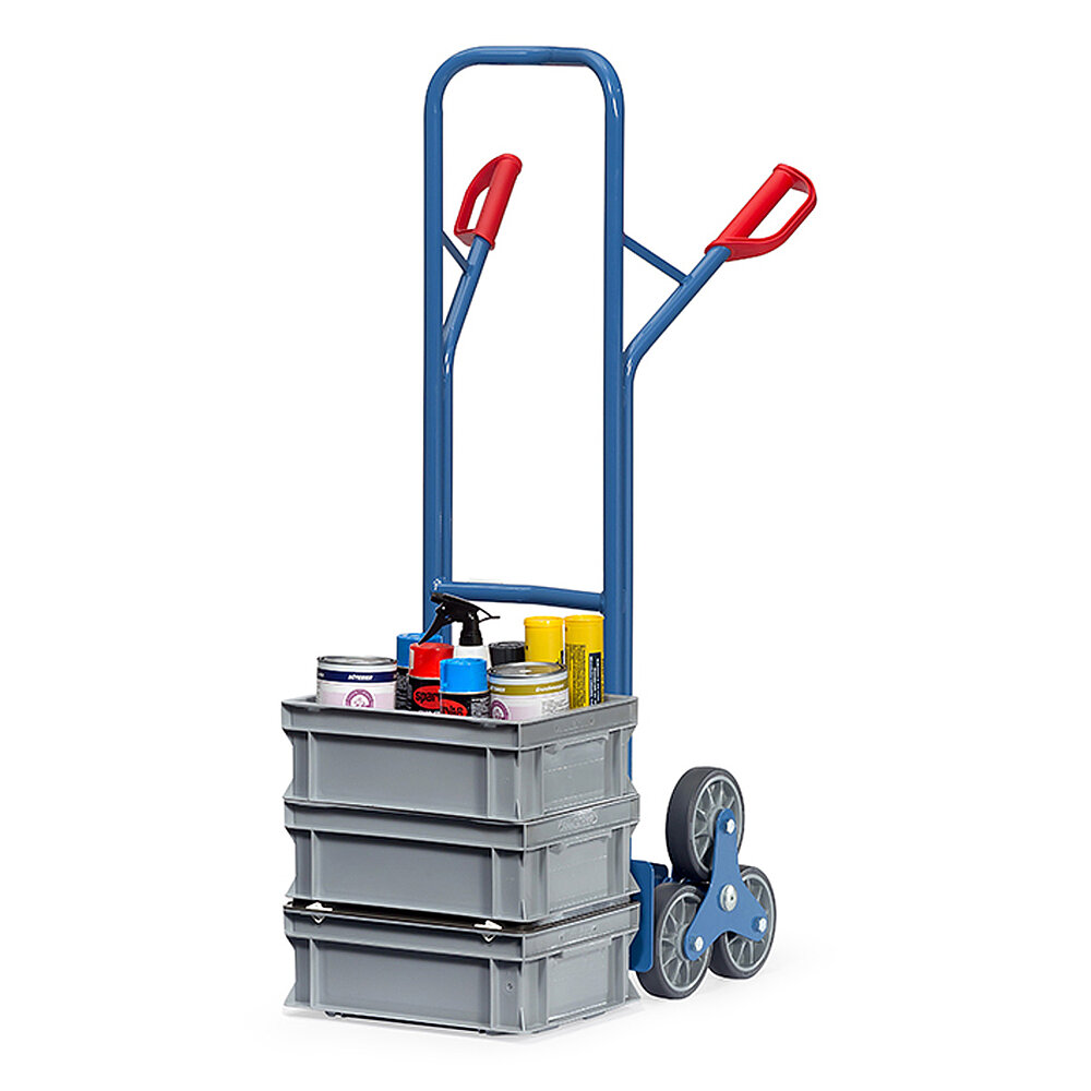 a blue FETRA® stairway truck made of steel tubes, with three-armed wheel hub, red handles and loaded with three grey stacking boxes, isolated on white background