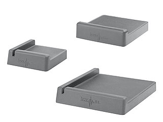 a group of three light-grey square elastomeric formpieces of various sizes with length- and sideway crossbars and fine, parallel grooves on the surface, isolated on white background