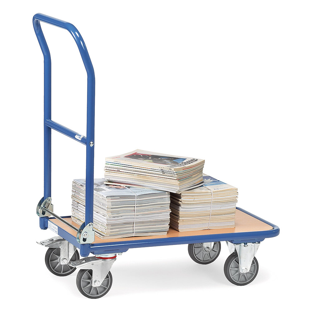 a blue FETRA® collapsible cart made of steel tube with low, rectangular platform of light-coloured wood, collapsible push bar, two fixed wheels at the front, two steering wheels at the rear, and loaded with three bundles of magazines, isolated on white background