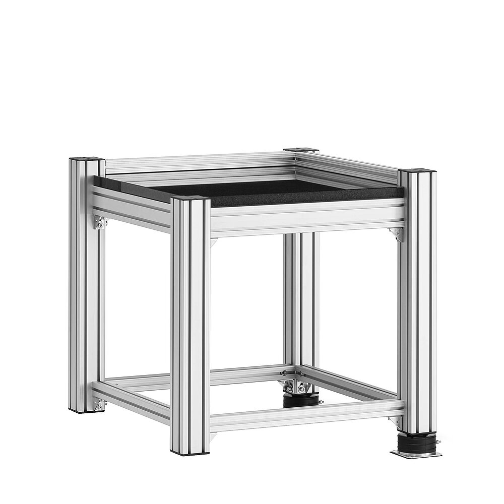 a square, cube-shaped metrology table made of aluminium profiles, with thick black granite table top, mounted on two black air-cushion vibro-mounts FLN, isolated on white background