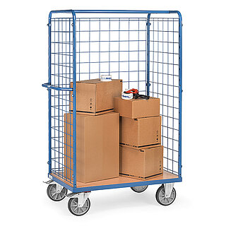 a tall blue FETRA® parcel cart made of steel tube with push bar, light-coloured wooden platform, steel mesh walls to three sides, two fixed wheels at the front, two fastenable steering wheels at the rear and loaded with five brown closed cardboard boxes, isolated on white background