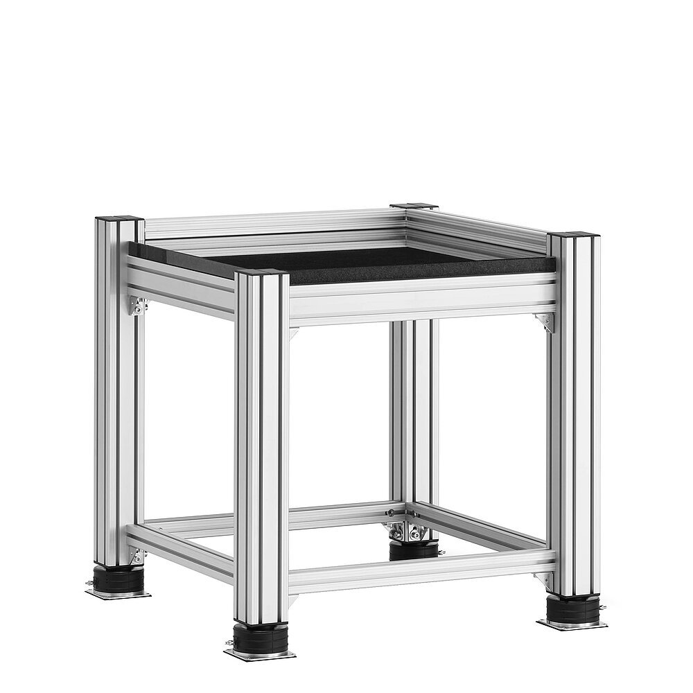 a square, cube-shaped metrology table made of aluminium profiles, with thick black granite table top, mounted on black air-cushion vibro-mounts FLN, isolated on white background
