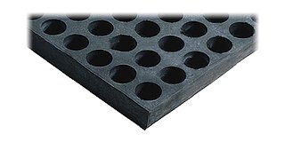 Ausschnitt einer dicken, schwarzen, quadratischen Platte aus Nitrilkautschuk, mit strukturierter Oberfläche aus zylinderförmigen Vertiefungen, für niederfrequente Schwingungsisolierung und Passivisolierung unter Maschinen, freigestellt auf weißem Hintergrund