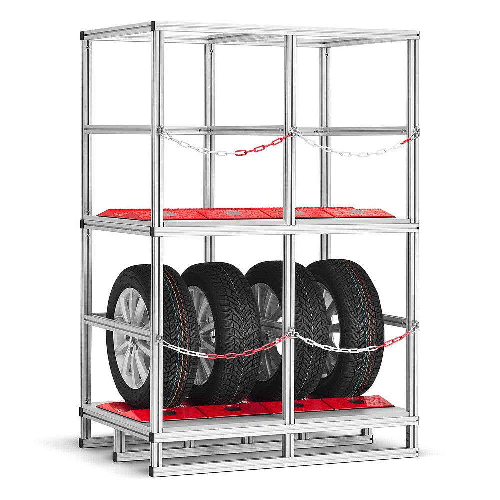 a tyre rack made of aluminium profiles with two storeys, each lined with red TyreGuard® tyre protectors and the lower storey loaded with four tyres on alloy rims, both storeys secured with a cross-wise chain, isolated on white background