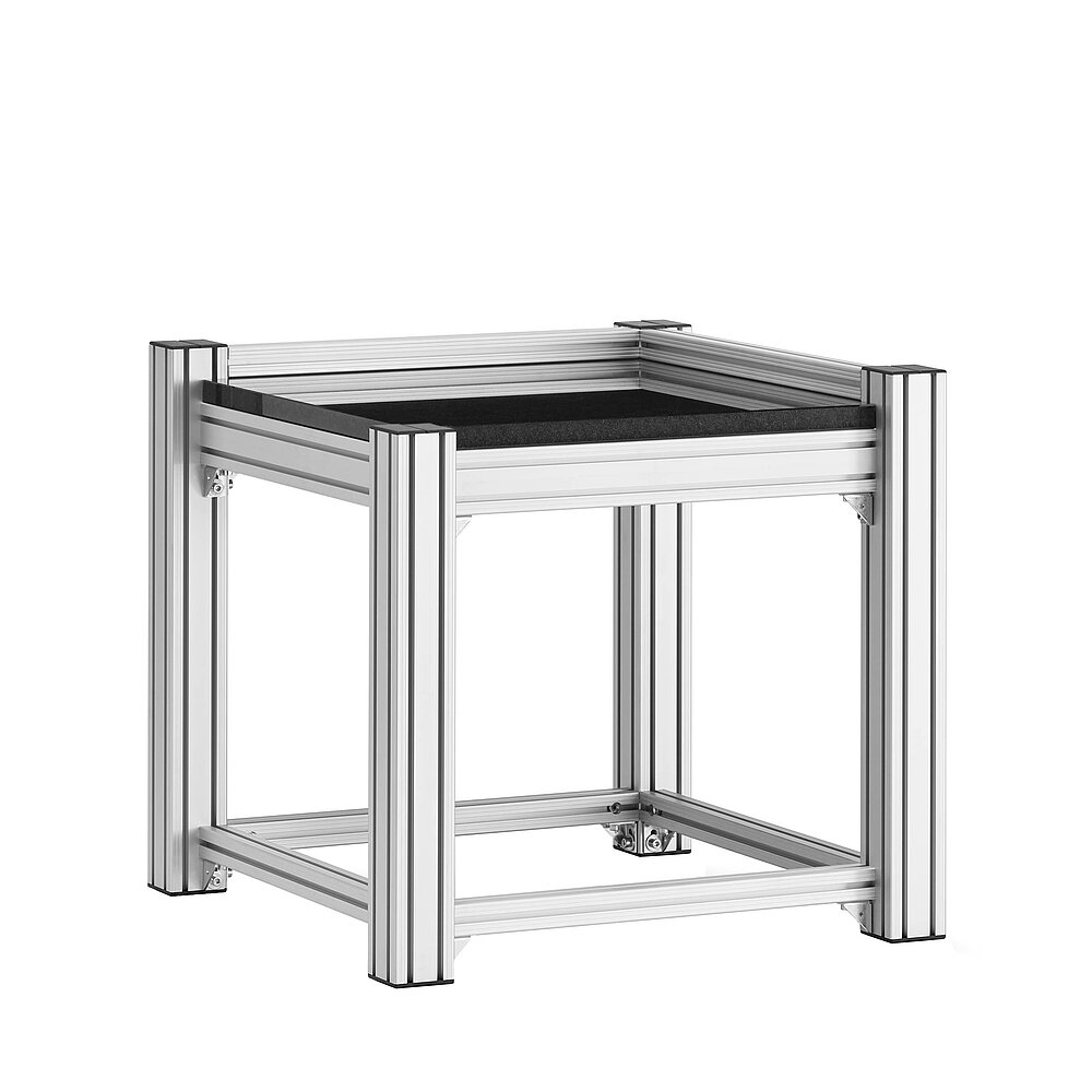a square, cube-shaped metrology table made of aluminium profiles, with thick black granite table top, without vibration isolation mounting, isolated on white background