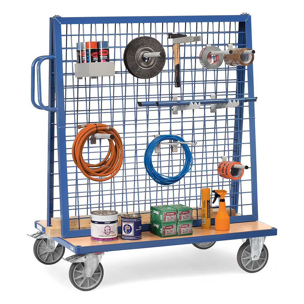 a blue FETRA® grated work piece trolley with various light-grey hooked-in fastening components, and equipped with diverse tubes, tools, work pieces and work utensils, isolated on white background