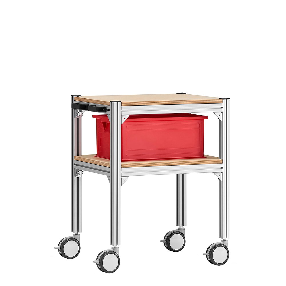 a small trolley made of aluminium profiles, with two storeys, wooden inlay shelvings, black pushbar handle made of plastics, four large, fastenable & turnable wheels and one red EURO stackable box in the bottom shelf, isolated on white background