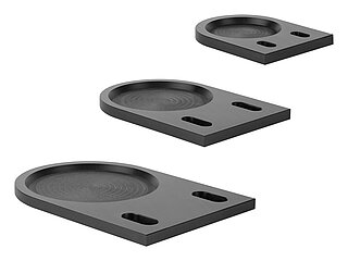 three black fastening plates of various sizes, made of milled compound material with elongated holes for floor-anchoring, suitable for levelling elements, in the side view, isolated on white background